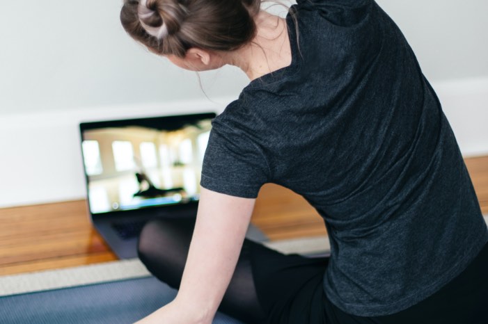 Woman streching in front of laptop