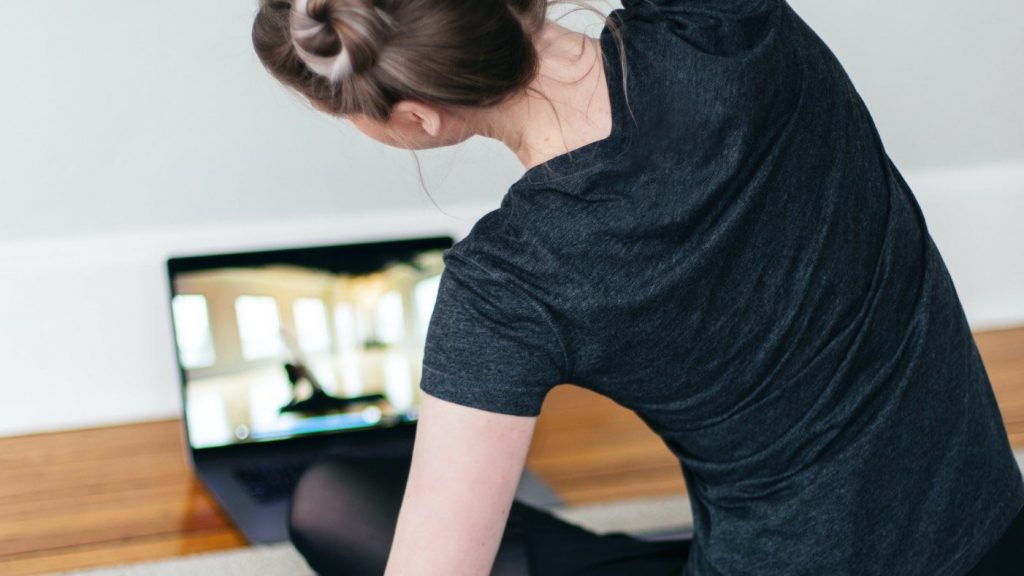 woman following coach on computer fitness training
