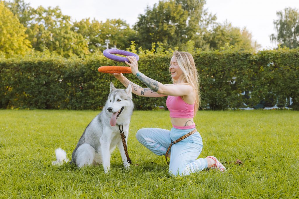 woman and dog playing park squat health fitness